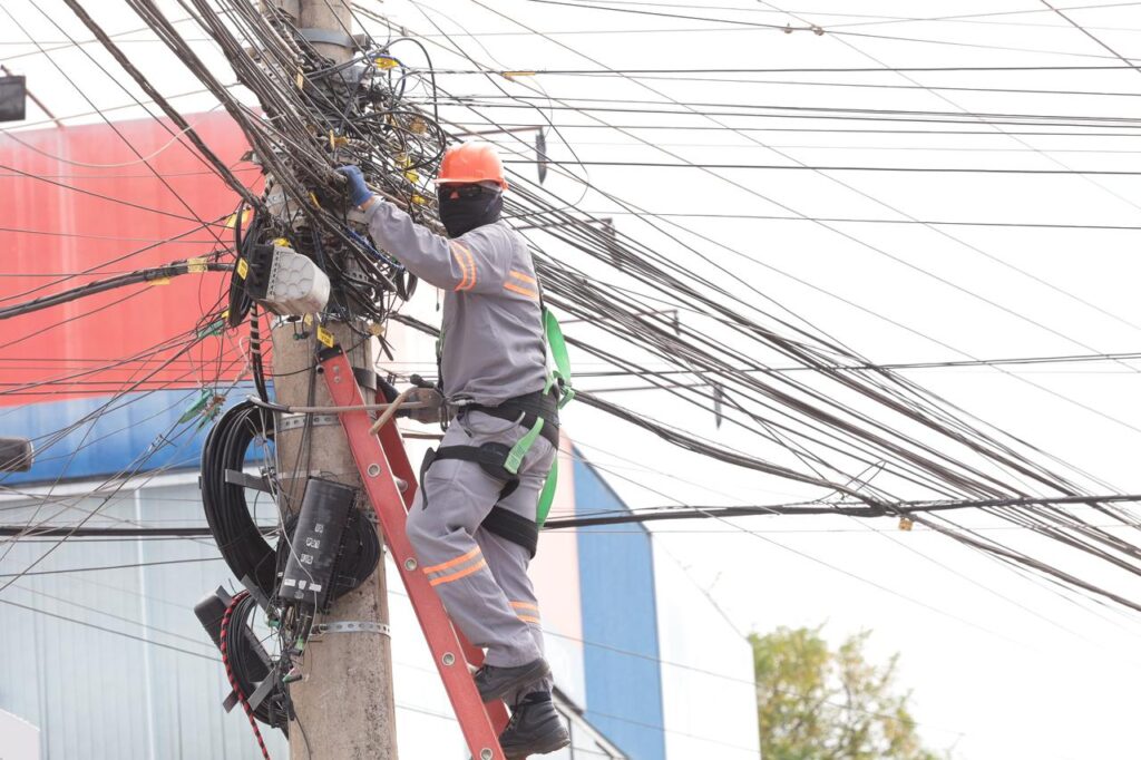 Operador sobre o poste (Foto: Rodrigo Estrela/Secom Aparecida)